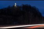 U hlavní silnice z České Lípy do Liberce, nedaleko Nového Boru, svítí o Velikonocích kříž