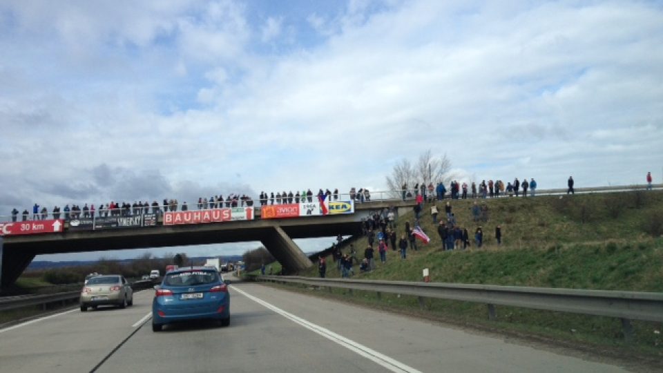 Konvoj na D1 nedaleko Brna. Vojákům na mostě mávají desítky lidí