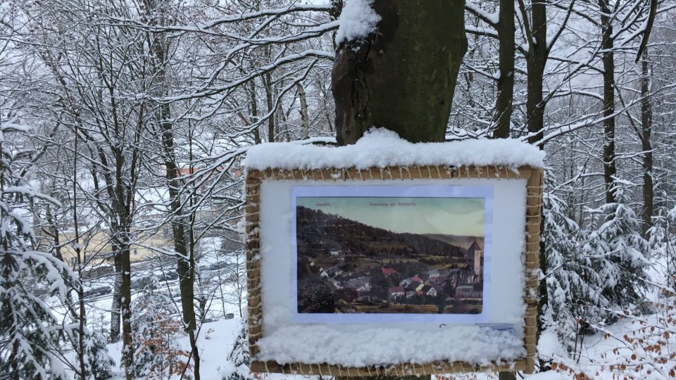 Na stromech podél cesty jsou umístěny historické fotografie a pohlednice Nejdecké křížové cesty