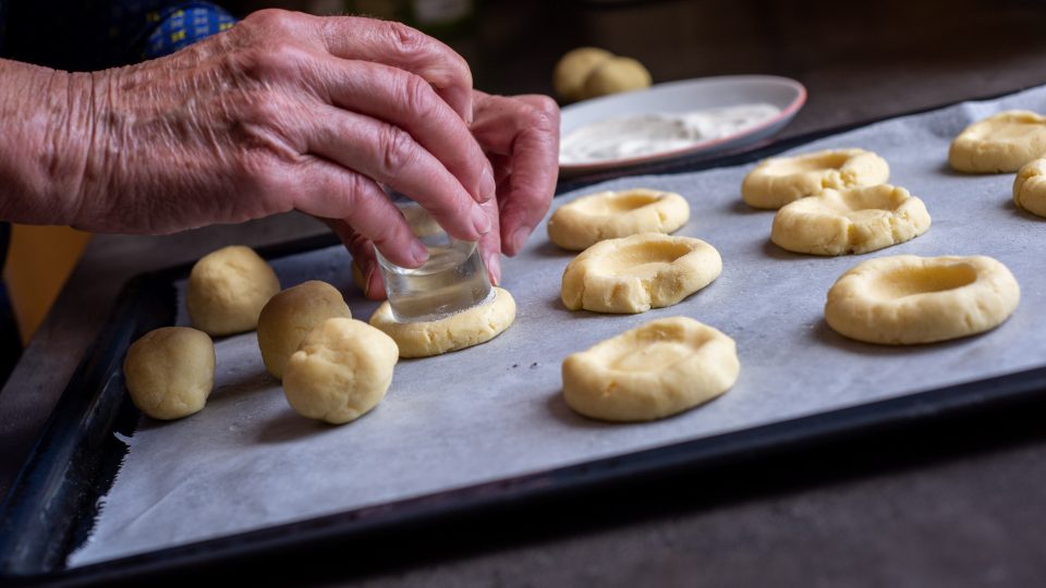 Z těsta tvarujeme kuličky a do nich pomocí skleničky děláme důlky | foto: Martin Čuřík Z těsta tvarujeme kuličky a do nich pomocí skleničky děláme důlky
