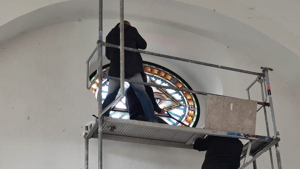 Usazování kopie vitráže nad oltář kostela v Kunraticích u Cvikova
