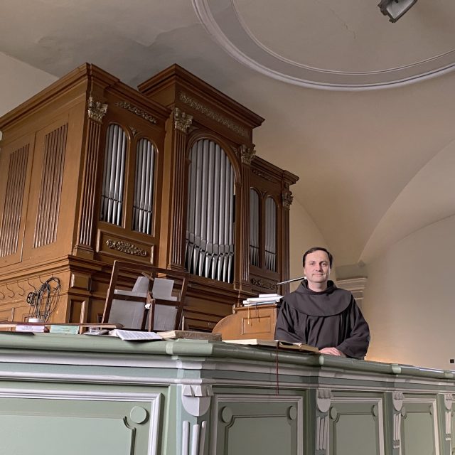 Farář kostela svatého Jana Křtitele v liberecké Rochlici  Dominik Valter u kostelních varhan | foto: Lucie Fürstová,  Český rozhlas