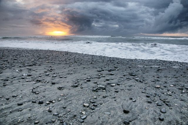 Slunce nízko nad obzorem na novozélandské pláži | foto: Michal Kroužel